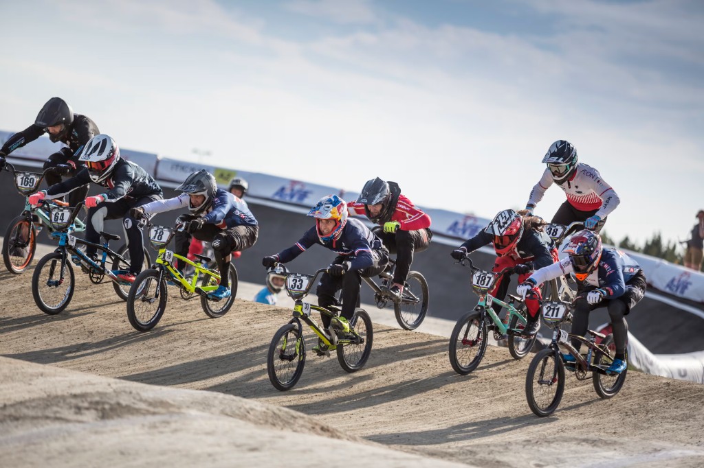 Corrida de BMX com vários competidores na pista ao ar livre